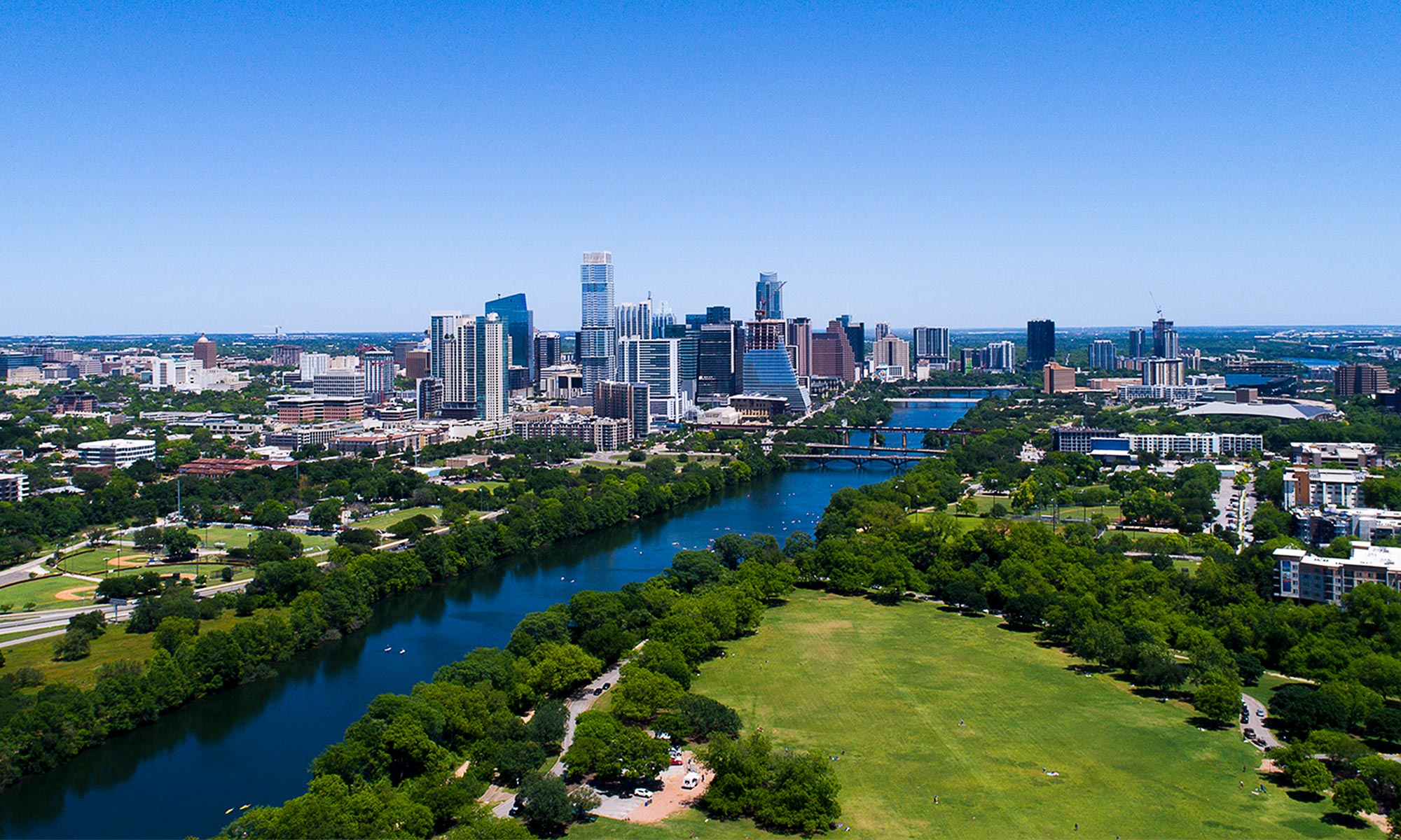Austin, Texa, skyline with Lady Bird Lake in foreground and the Pflugerville and Congress Avenue bridges