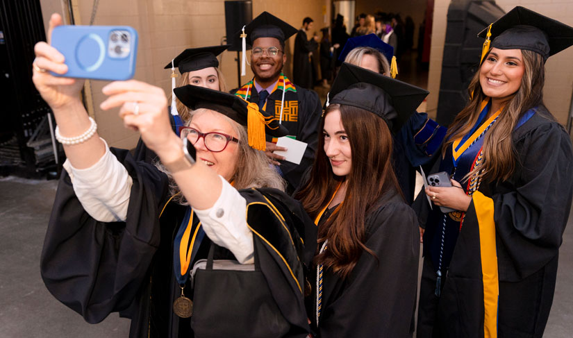 St. Edward's graduates pose for a selfie prior to entering the 2022 Commencement celebration arena