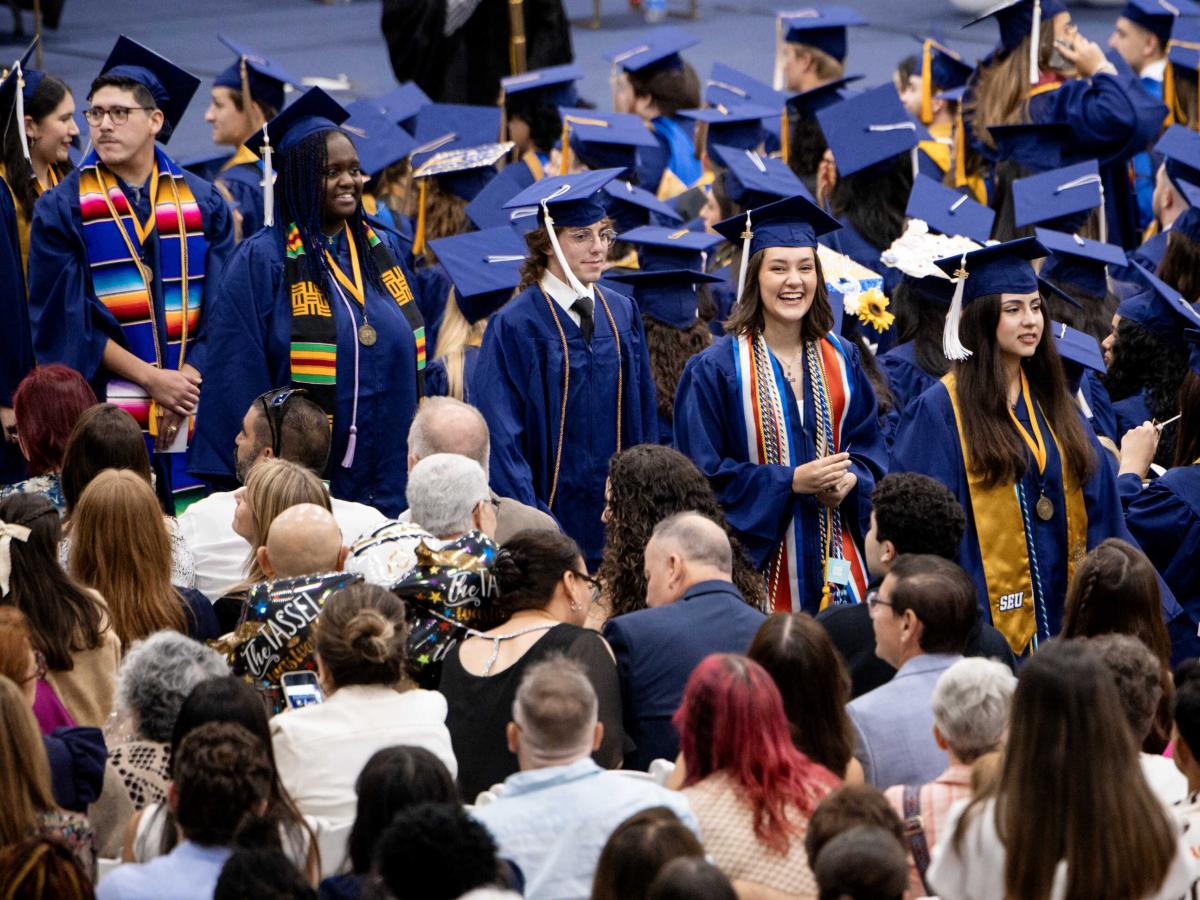 Graduates walk to their seats during commencement