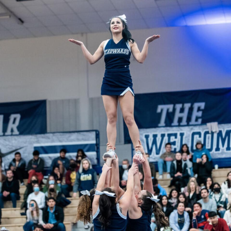 Cheerleader at the top of a pyramid foramtion 
