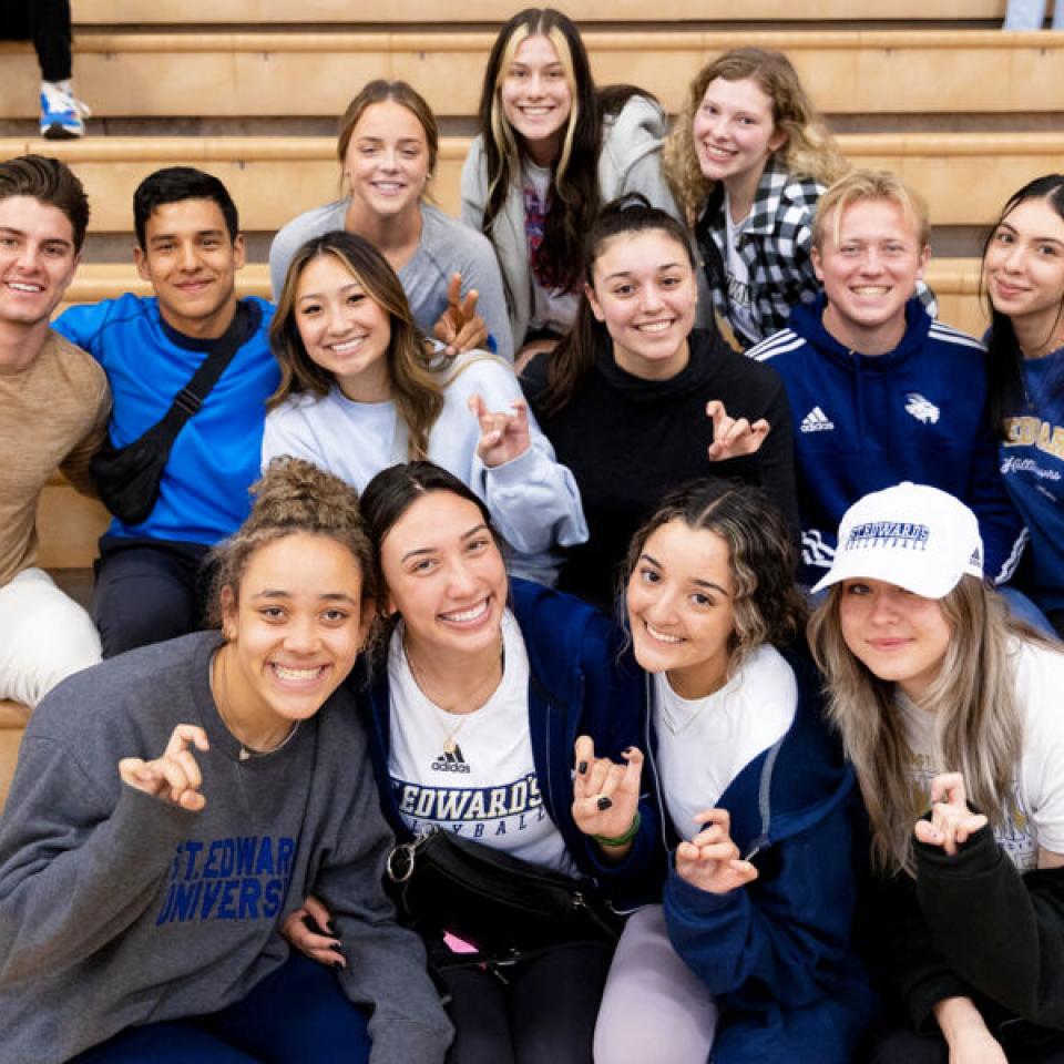 students cheering in the stands at a basketball game 