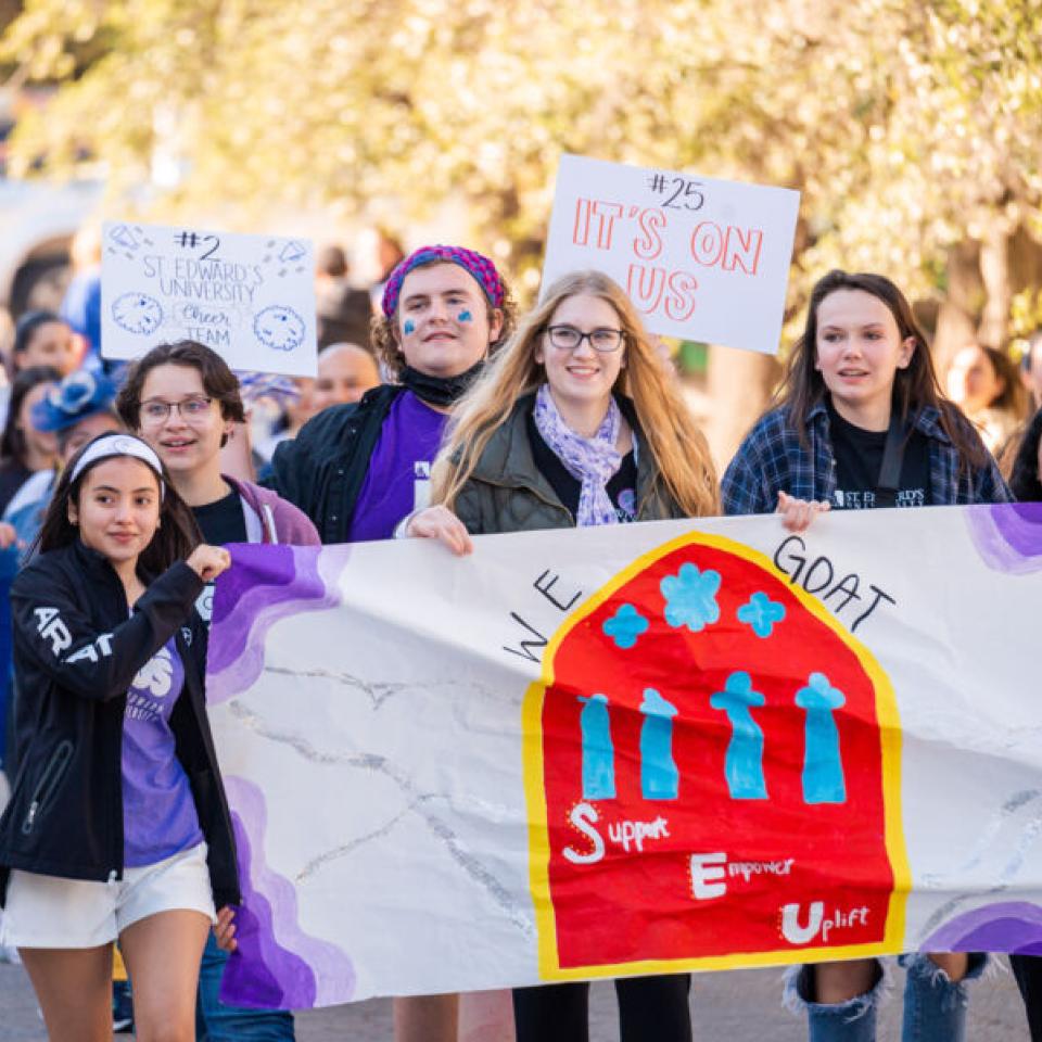 Students holding student empowerement banner at homecoming parade 