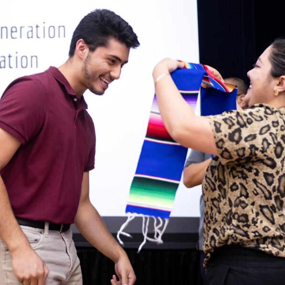 student getting hooded with latinx stole