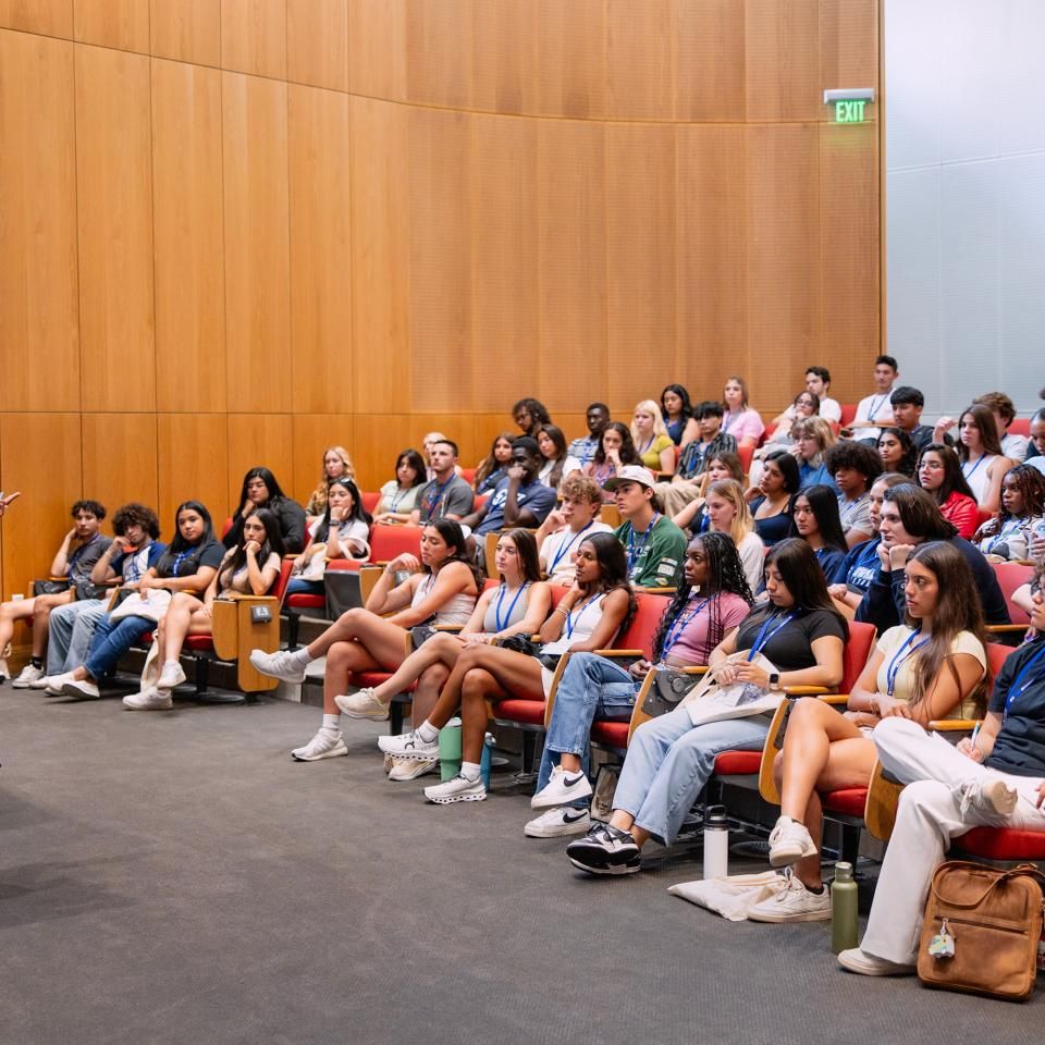 A group of people is seated in auditorium seating watching a presenter in Carter Auditorium Auditorium