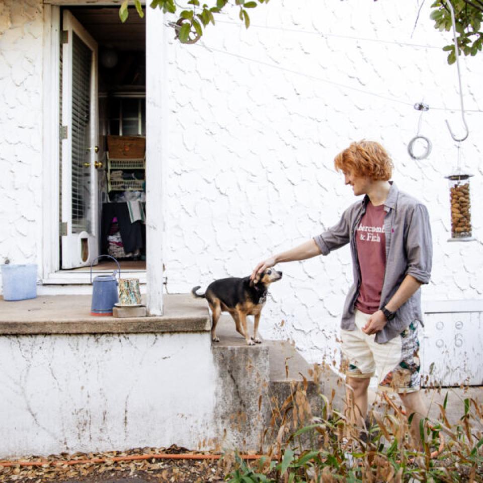 Ethan Burd pets his dog at his Austin childhood home