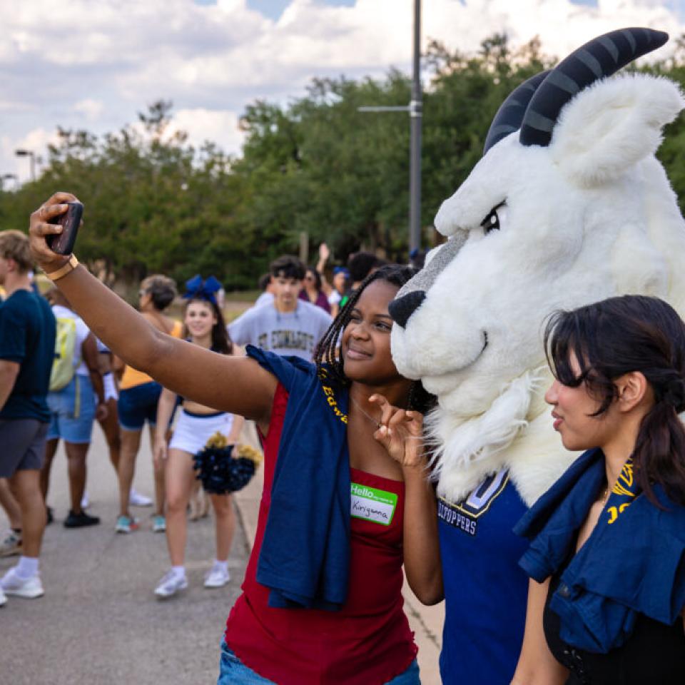 Students pose for a photo with Topper at block party.