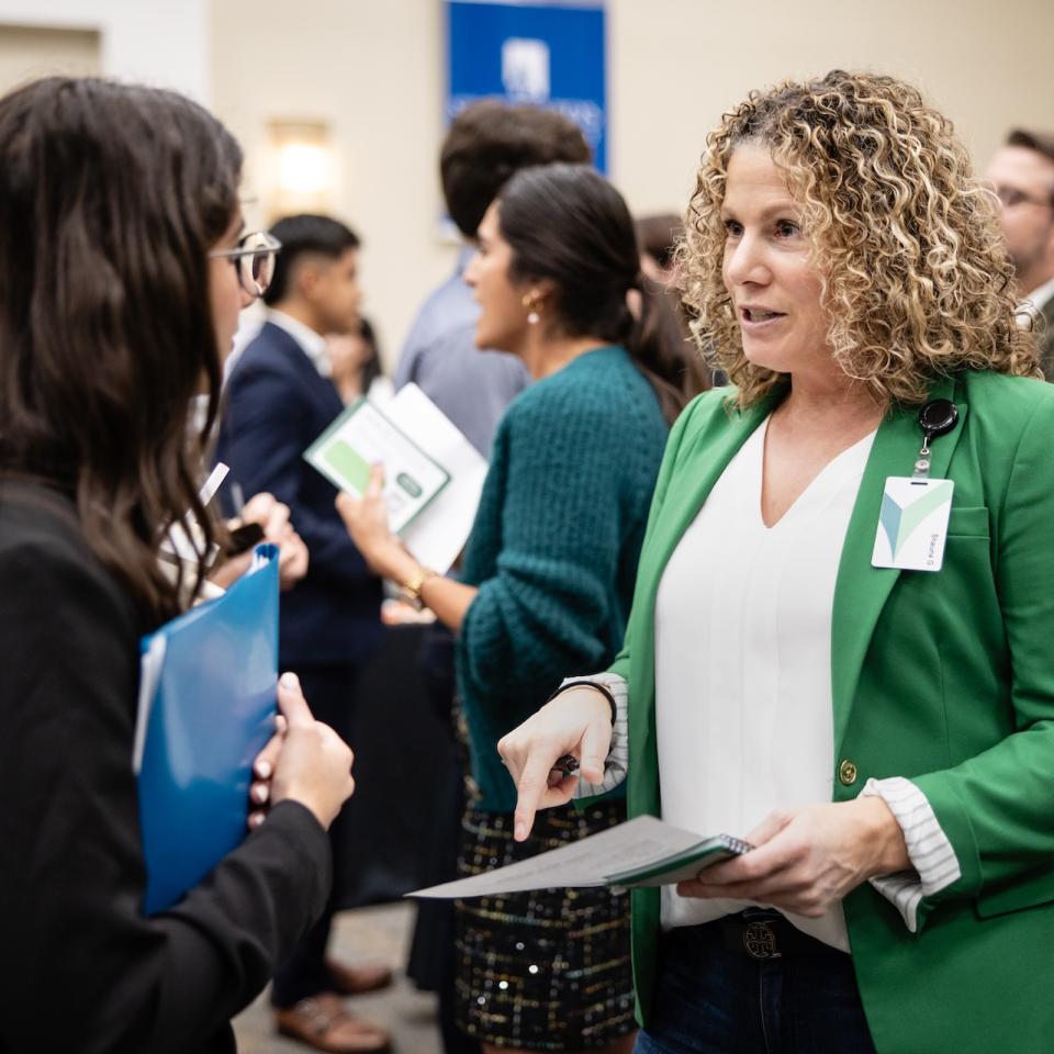 Two women having a conversation at an event.