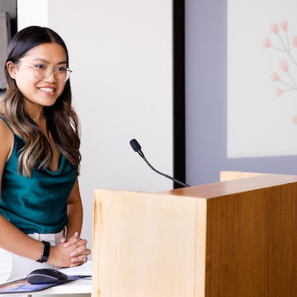Female Asian students at podium