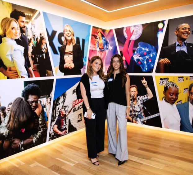 Students pose by a SXSW mural at their downtown office