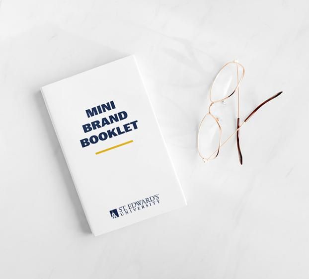 Mini brand booklet on a white table with a pair of eye glasses nearby