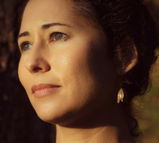 Close-up profile portrait of author Kirstin Valdez Quade, lit by warm sunlight, looking off-camera.