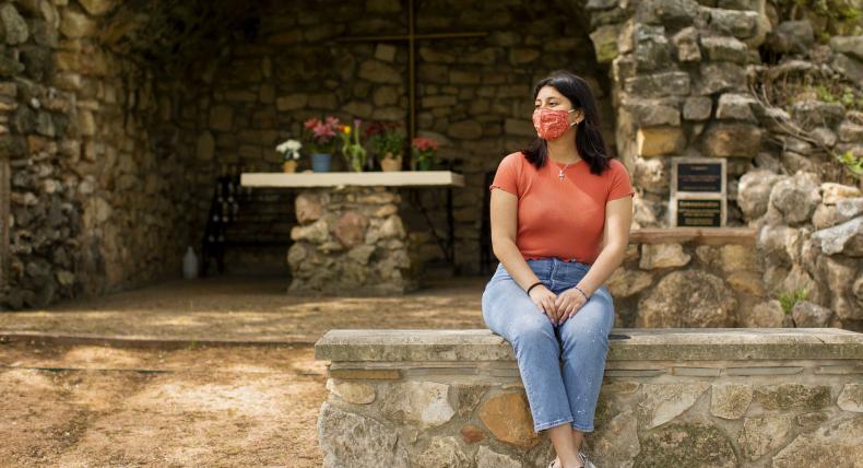 Darianna Diaz Ascencio reflects at the Grotto on campus.