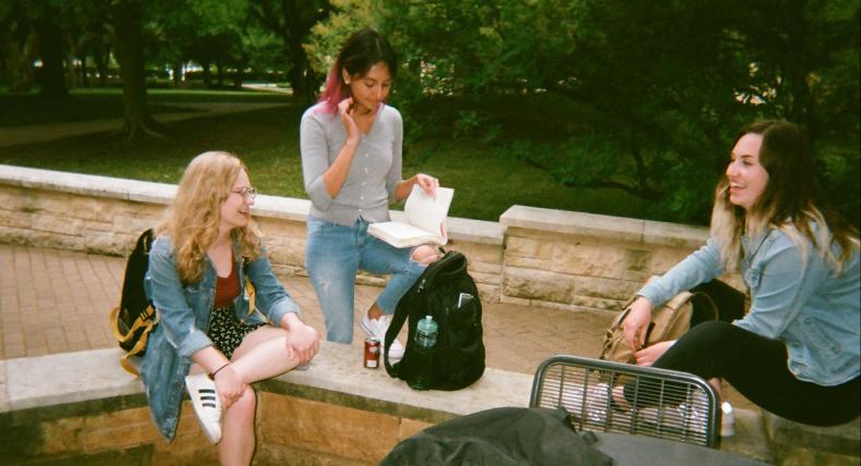 Students hang out behind Main Building chatting