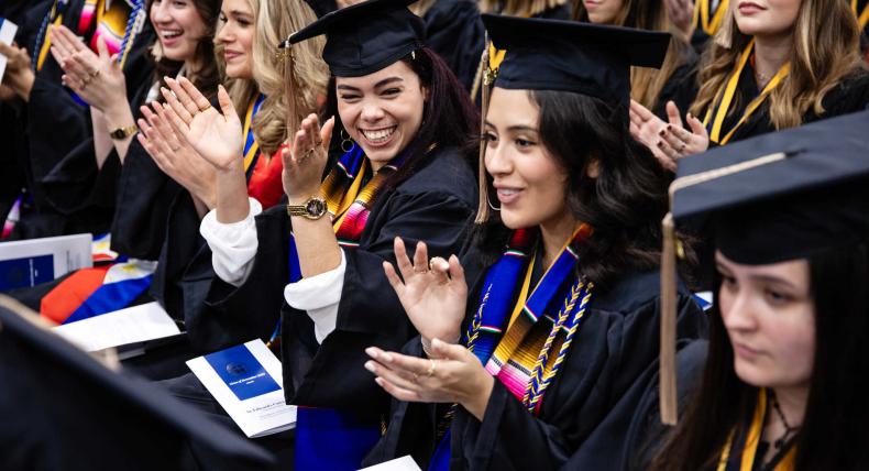 Students clap at the December 2023 Fall Commencement
