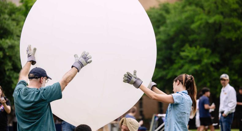 Students release a weather balloon during a solar eclipse on campus