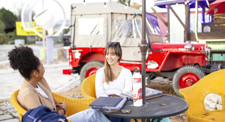Two students chat outside of a coffee shop on South Congress