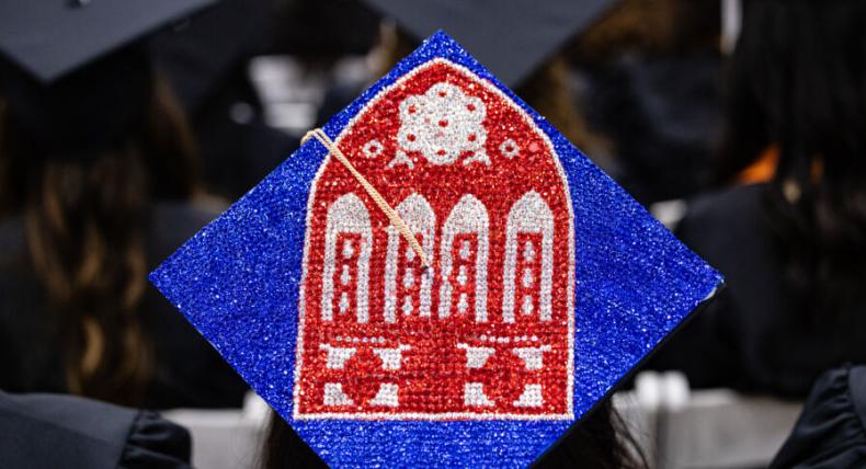 Graduating senior creates Main Building Red Doors image on their cap for December 2024 Commencement.