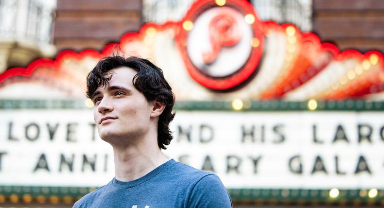 Sam McFarland poses in front of the Paramount Theater in downtown Austin