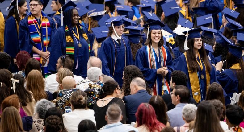 Graduates walk to their seats during commencement