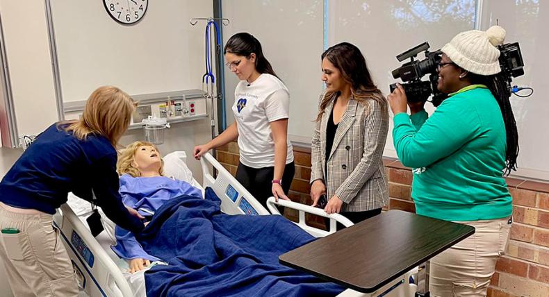 Katy Allen demonstrates how to use a manikin to nursing students and KXAN News.