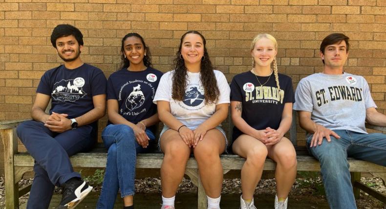 5 St. Edward's Students sitting on a bench