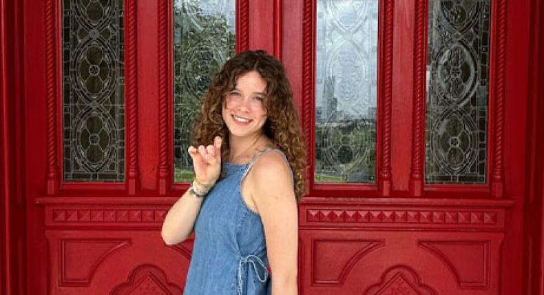 Social Work student Lily Grant poses for a photo outside of the Red Doors. 