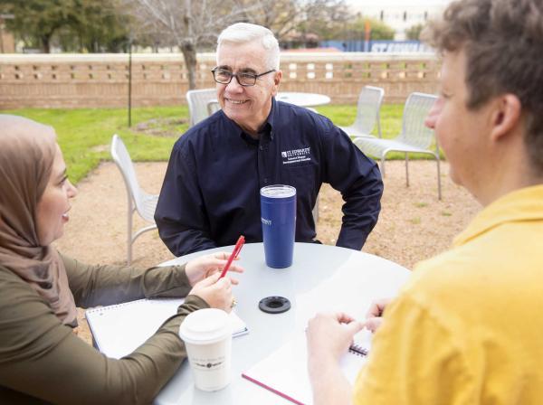 Graduate Professor talking to students outside of class