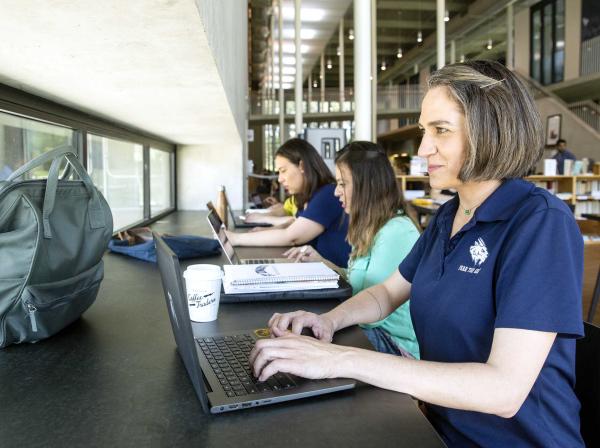 Grad Student using a computer in the library 