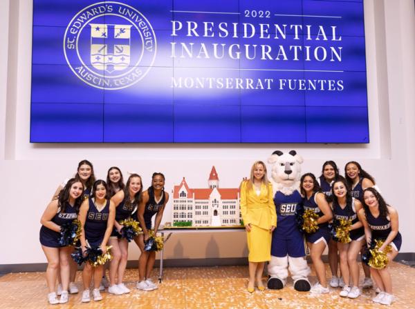 President Fuentes cutting the cake with St Edward's cheerleaders