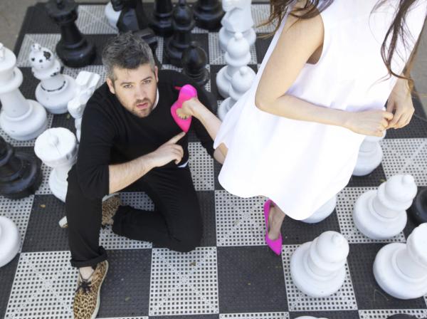 brandon MAxwell sitting next to a women in pink heels