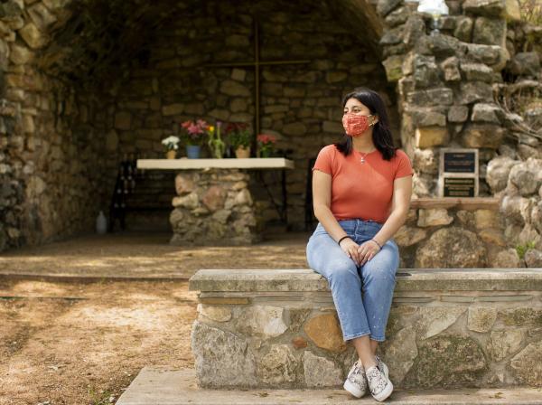 Darianna Diaz Ascencio reflects at the Grotto on campus.
