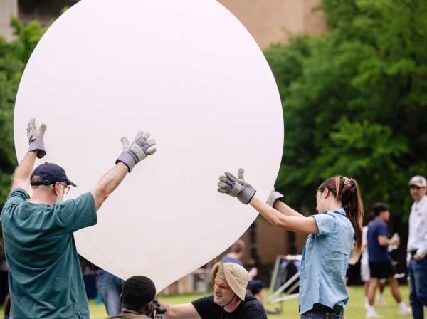 Students release a weather balloon during a solar eclipse on campus