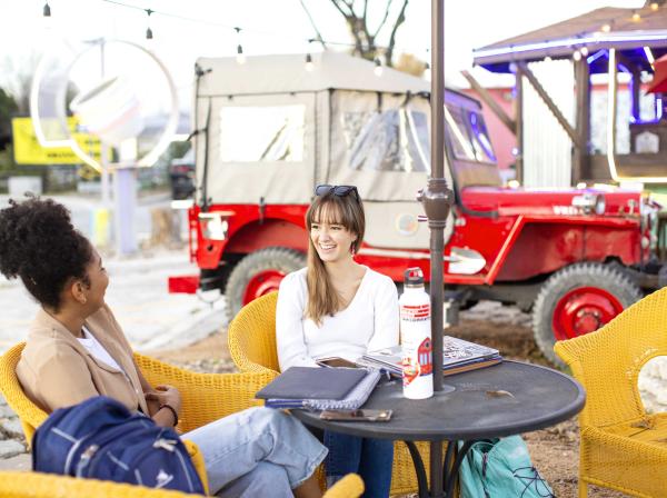 Two students chat outside of a coffee shop on South Congress