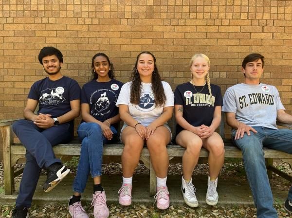 5 St. Edward's Students sitting on a bench