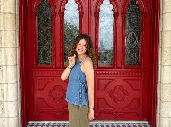 Social Work student Lily Grant poses for a photo outside of the Red Doors.