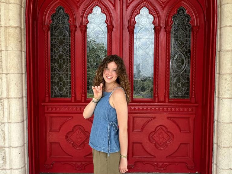 Social Work student Lily Grant poses for a photo outside of the Red Doors. 