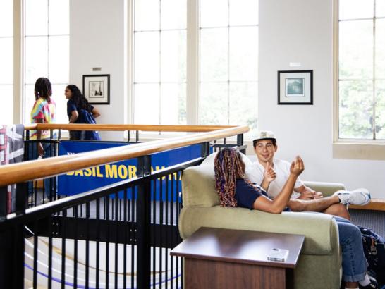 Students relaxing and socializing in residence hall common area at St. Edward’s University.