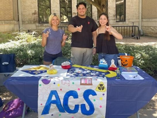 ACS students pose for photo at their display table during campus student organization event