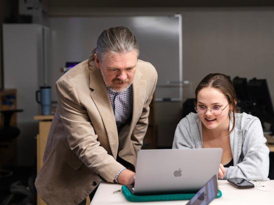 Professor helping student conduct research
