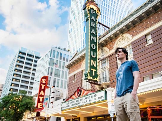 Alum Sam McFarland poses in front of the Paramount Theatre on Congress Avenue.