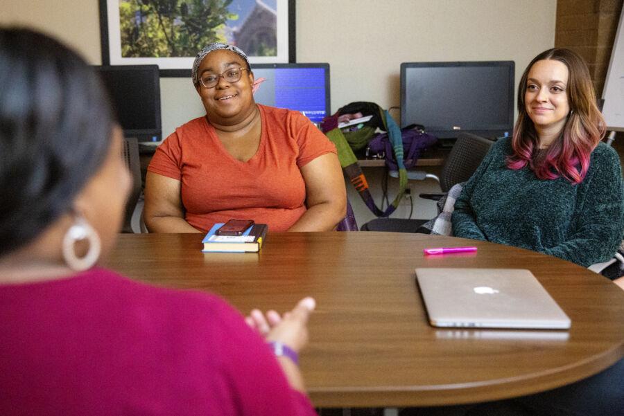 Counselor and patient chatting across a brown table during a session