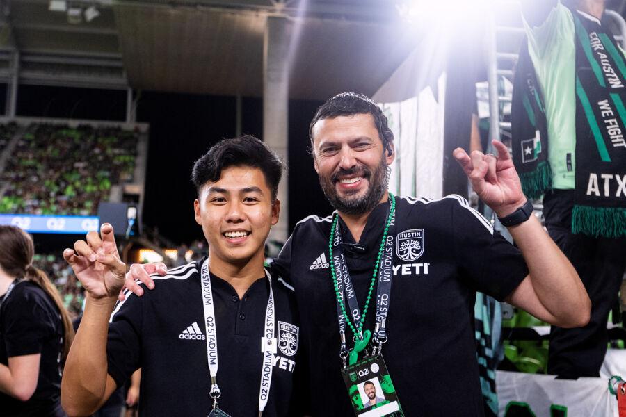 Tony Ho and Alfredo Naim putting toppers up at a Austin FC soccer game