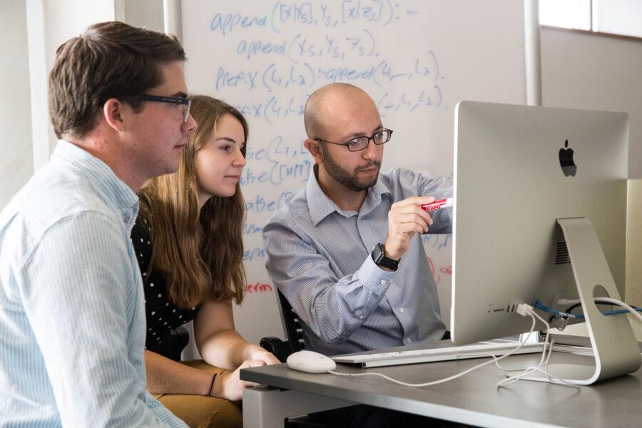 Professor Shebaro shows two students information on a computer screen.