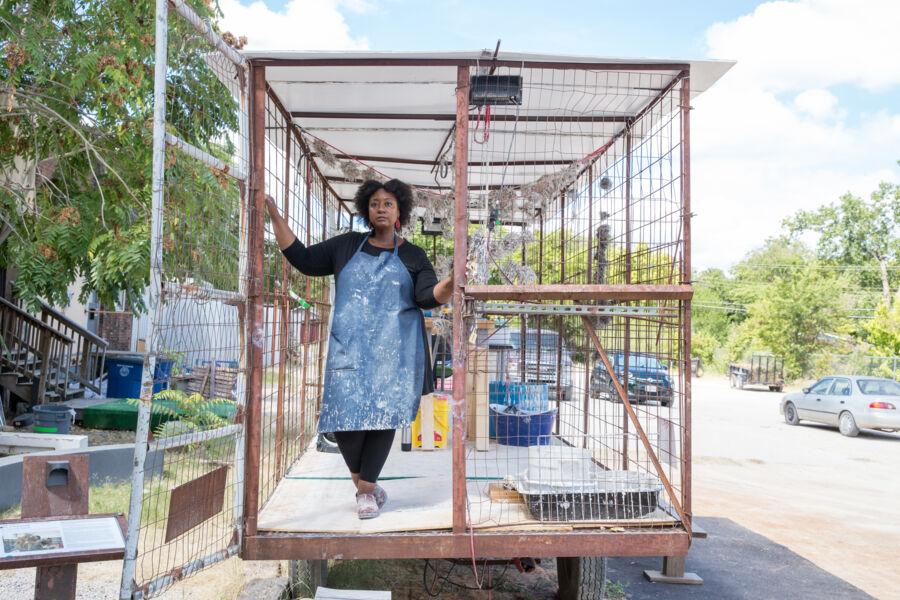 Tammie Rubin stands with her art in an outdoor studio.