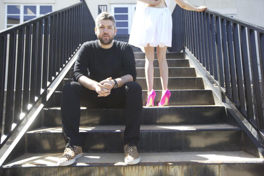 Brandon Maxwell sitting on a staircase next to a women with pink shoes 