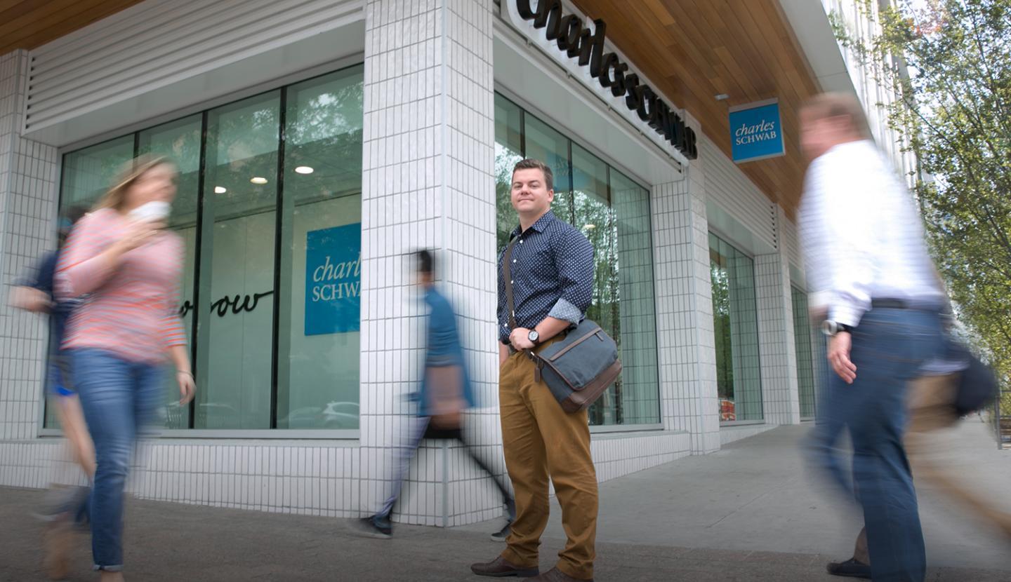 A student stands outside of a CHarles Schawaab office, where they are interning.