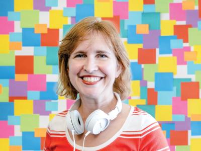 Professor with headphones against a colored checkered background 