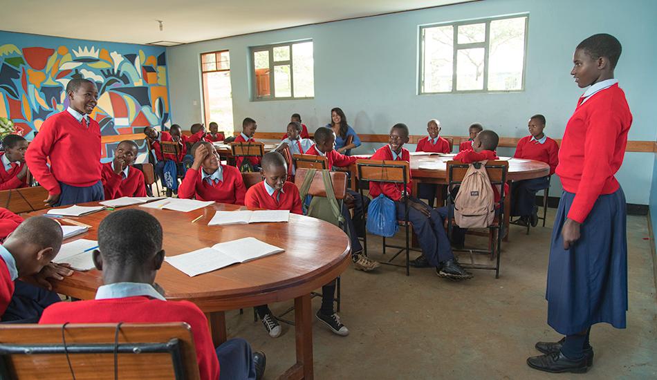 Student standing at the front of a classroom.