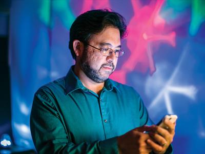 Man looking at his phone with colored background 