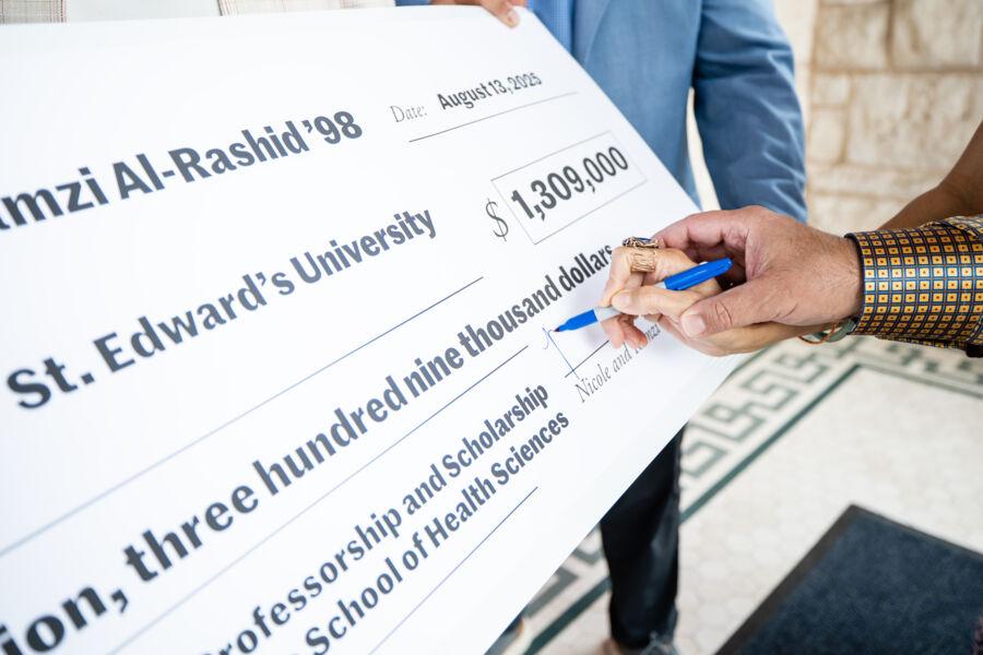 Nicole and Ramzi Al-Rashid sign a check for a $1.3 million gift towards the School of Health Sciences at St. Edward's.